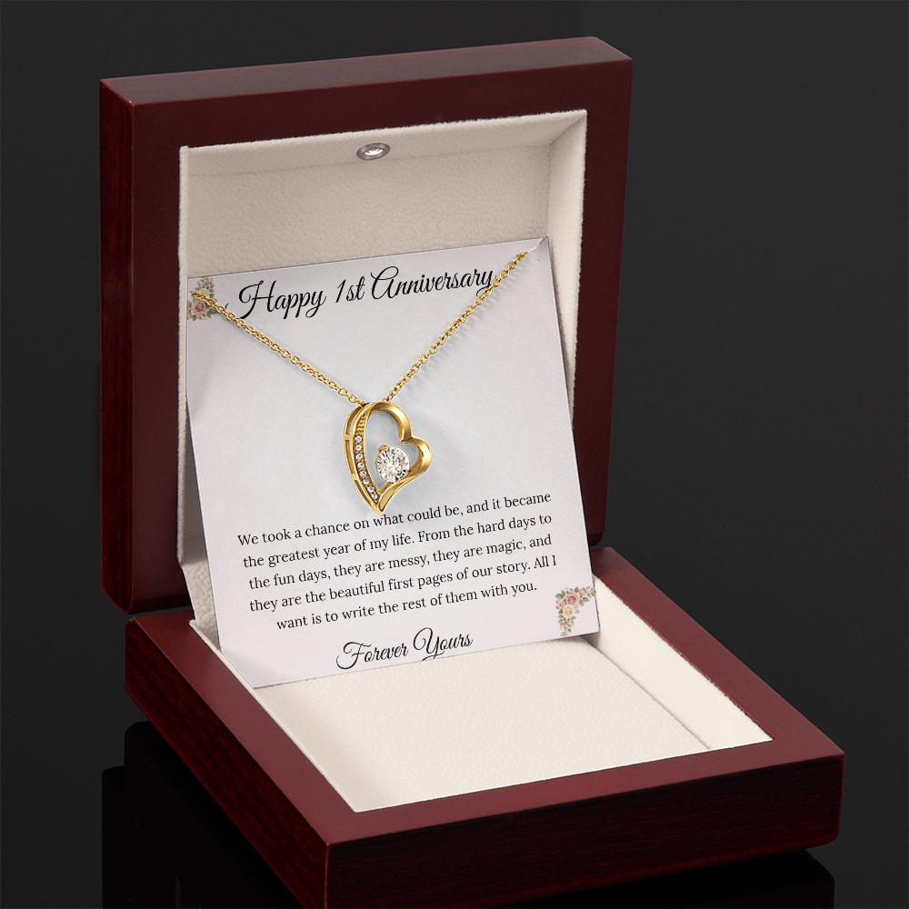 1st Anniversary gift for wife featuring a Forever Love heart necklace inside a luxury mahogany LED box. The pendant rests on a soft blush message card with blue floral corners and a romantic "messy and magic" quote