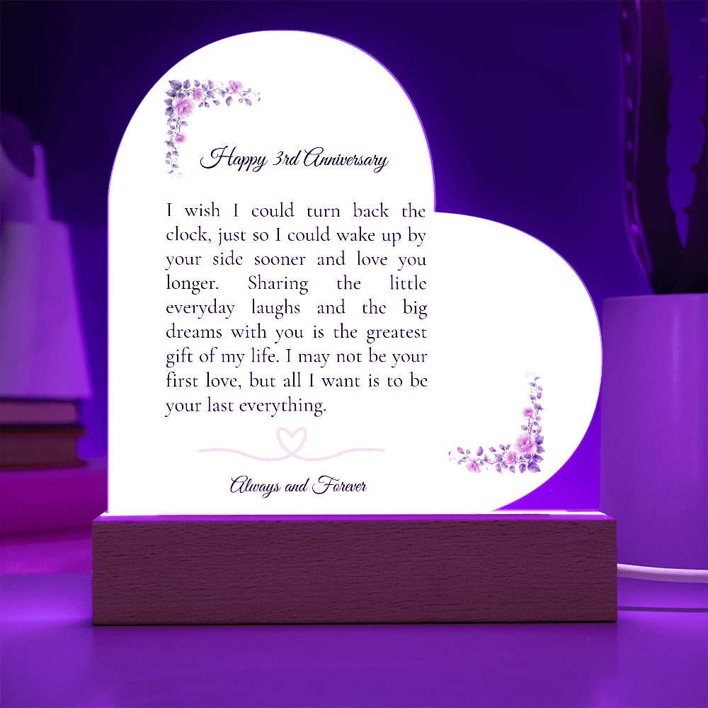 Heart shaped clear acrylic 3rd anniversary gift for wife on a glowing purple LED wooden base.
