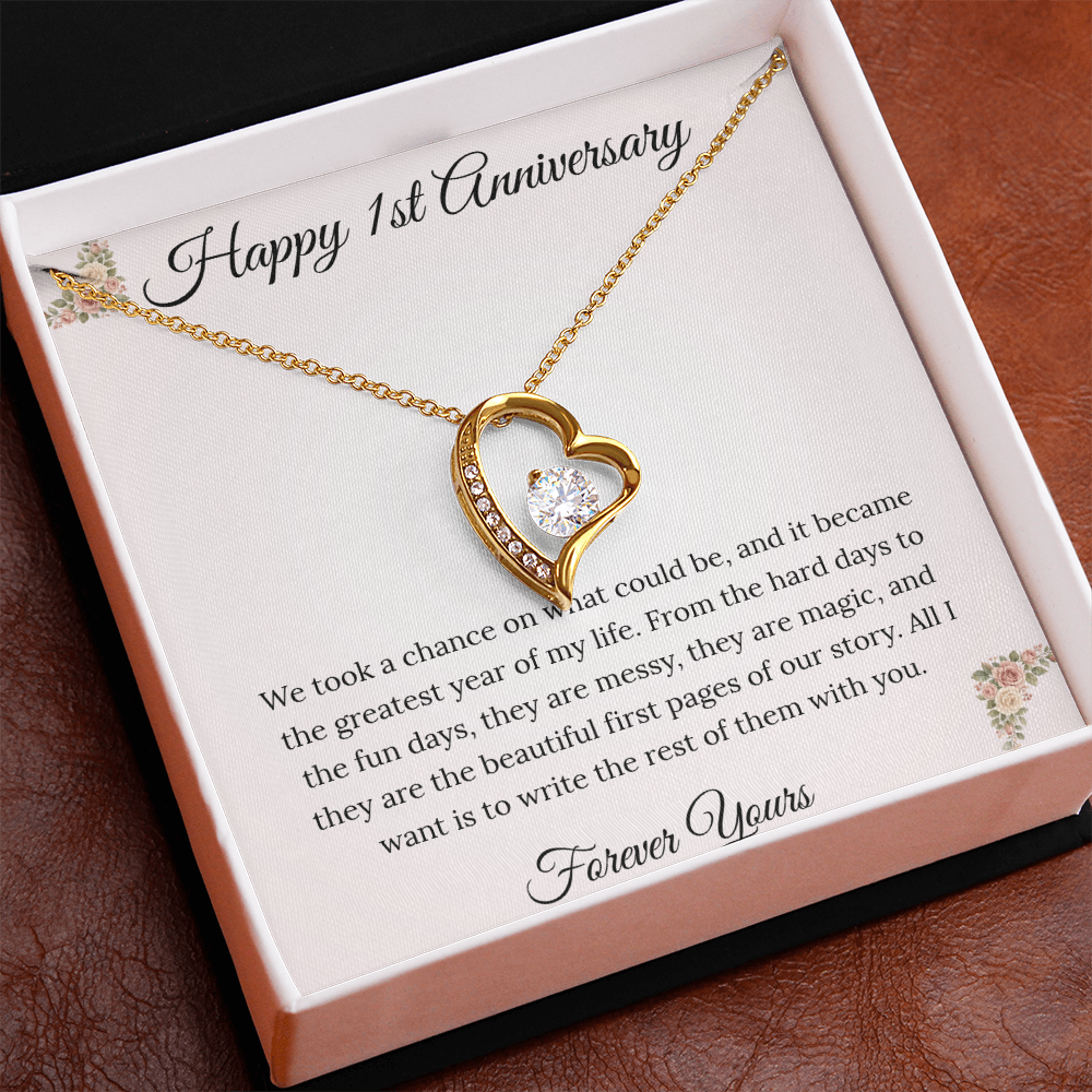 1st Anniversary gift for wife featuring a Forever Love heart necklace inside a luxury mahogany LED box. The pendant rests on a soft blush message card with blue floral corners and a romantic "messy and magic" quote